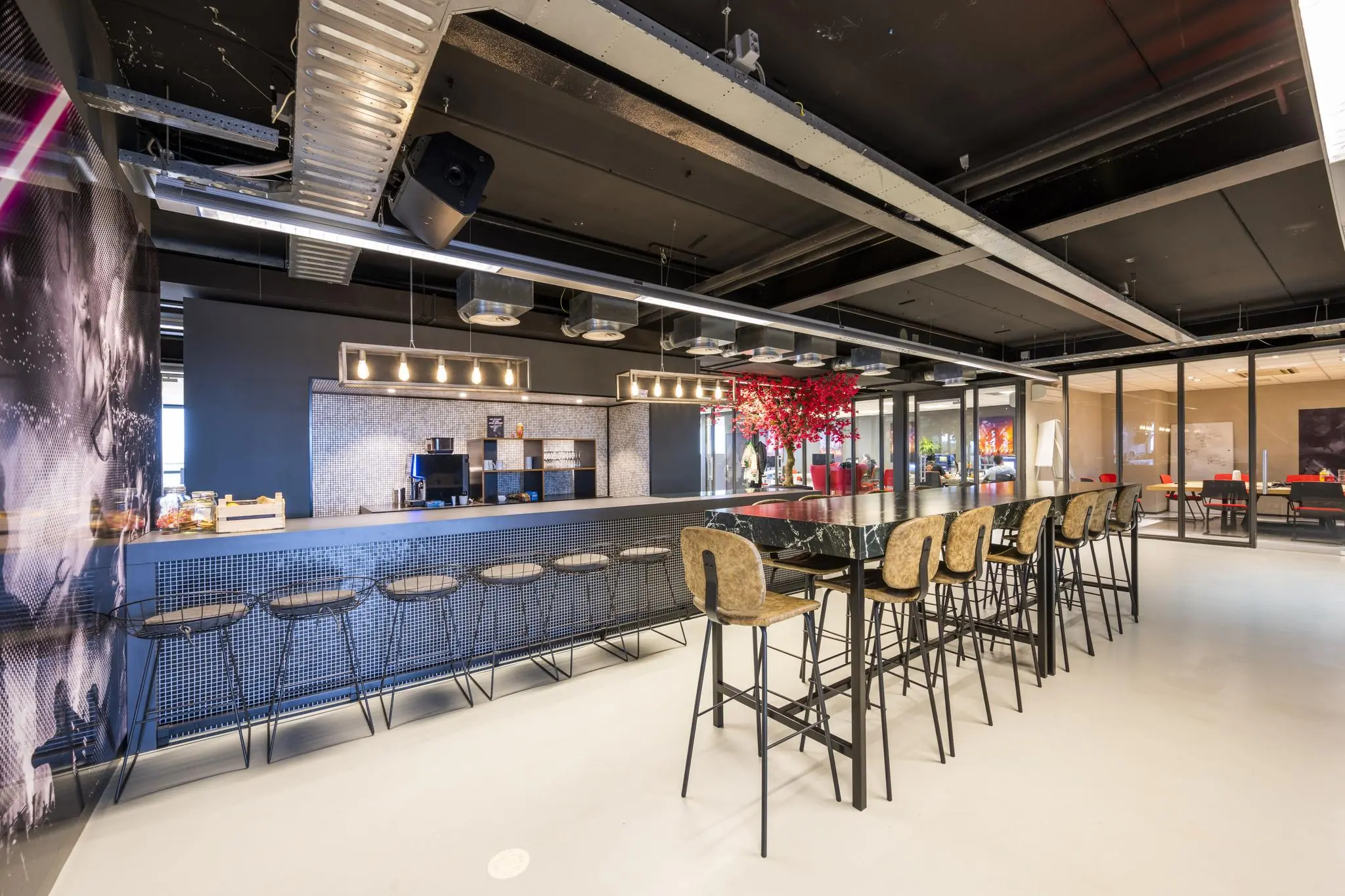 Moderne kantine aan de Anthony Fokkerweg met hoge zitplekken, koffiemachine en sfeervolle verlichting.